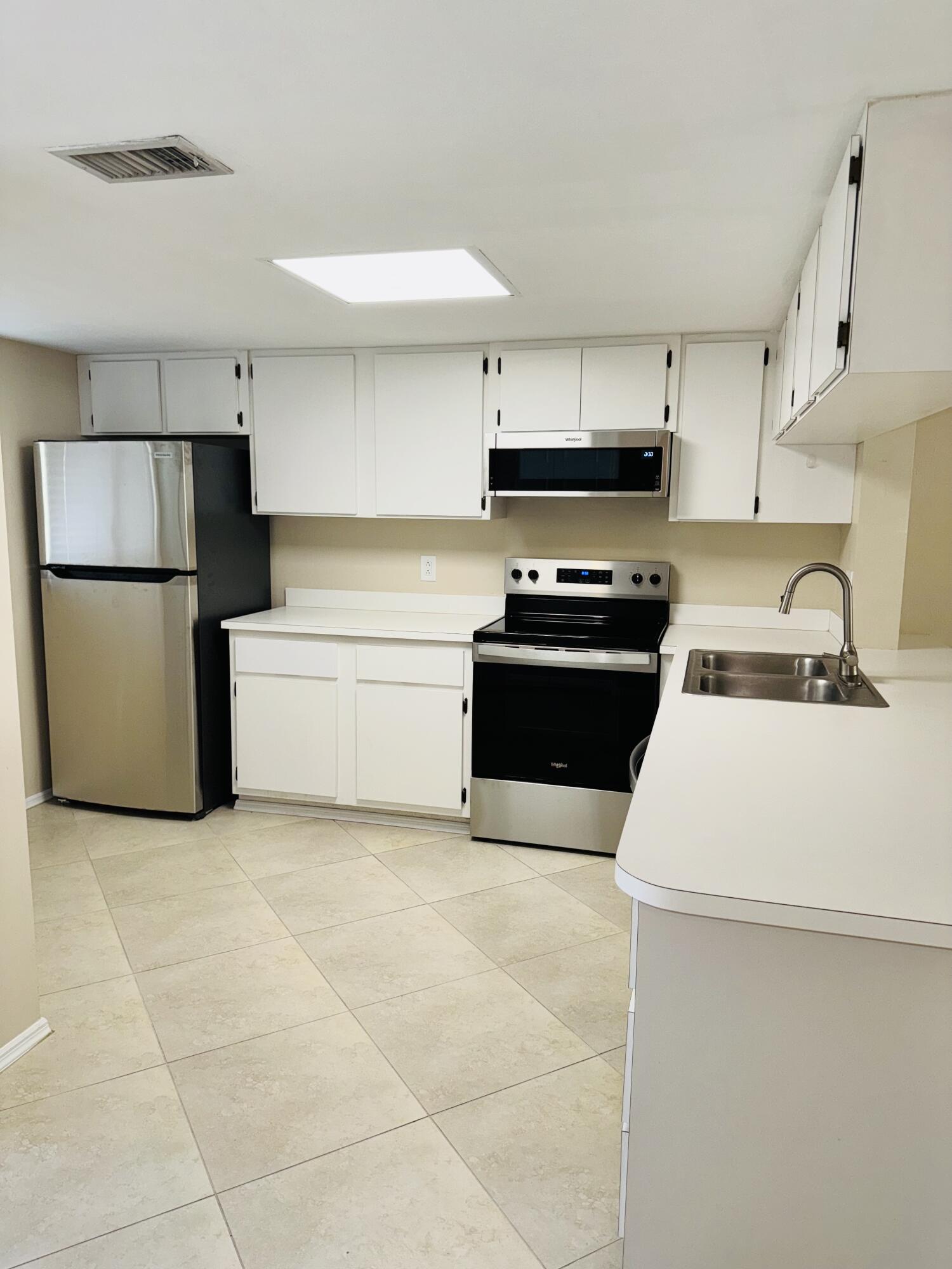 1708 Palm Beach Trace Drive Royal Palm Beach, FL 33411 - Photo 3 of 13 a kitchen that has a sink and a stove