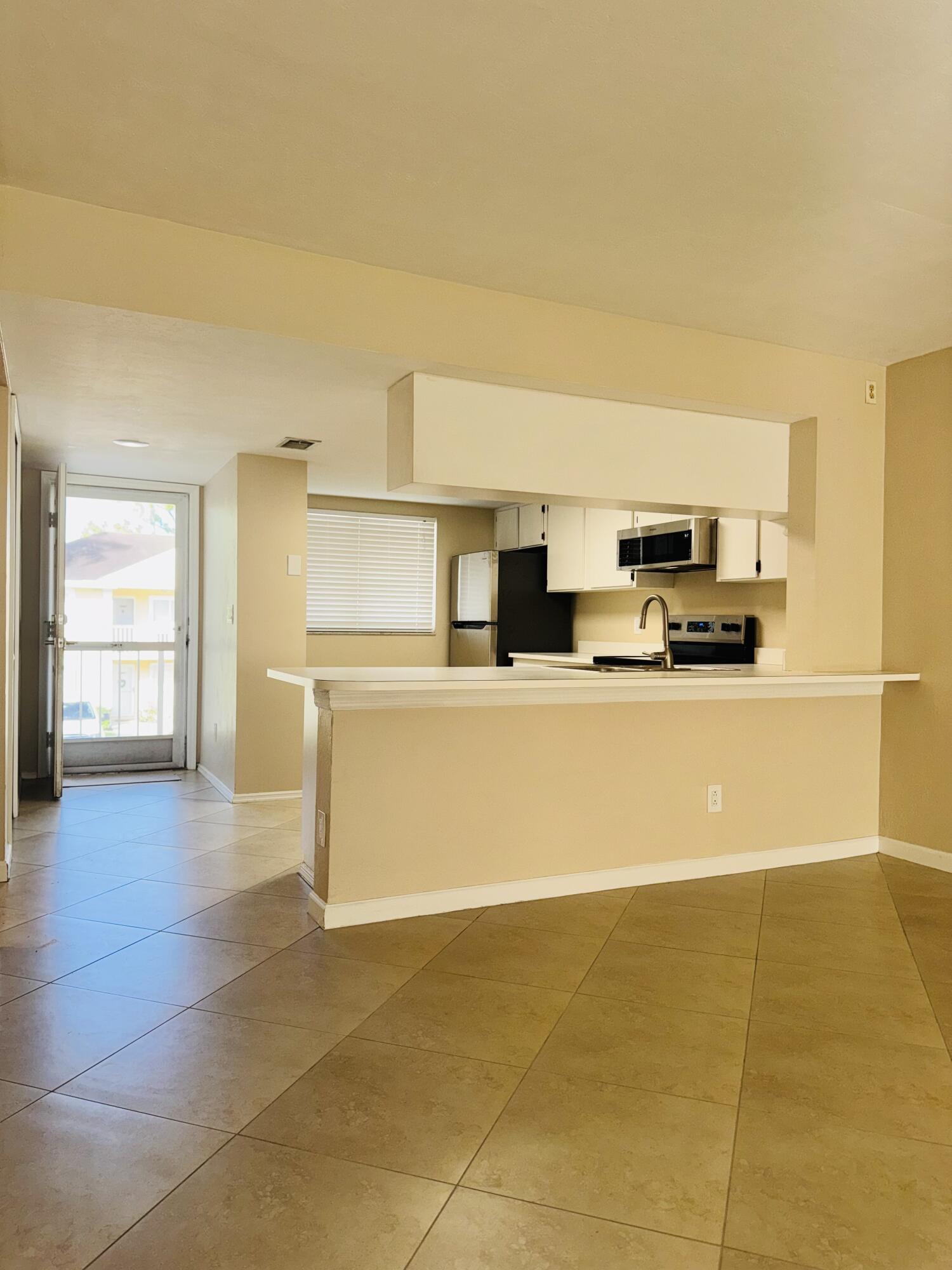 1708 Palm Beach Trace Drive Royal Palm Beach, FL 33411 - Photo 5 of 13 a view of a kitchen with stainless steel appliances a sink and cabinets