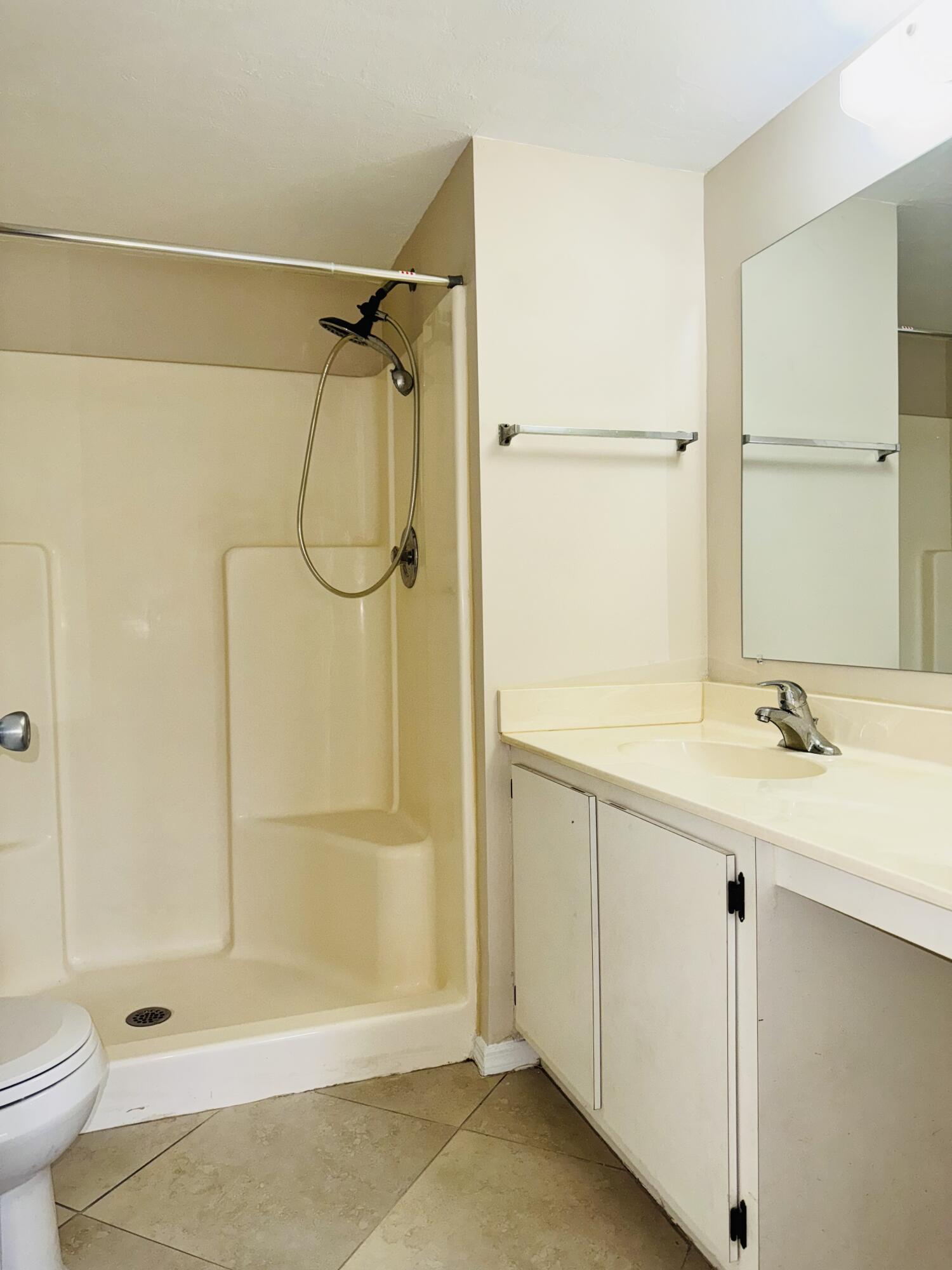 1708 Palm Beach Trace Drive Royal Palm Beach, FL 33411 - Photo 8 of 13 a bathroom with a shower sink and toilet