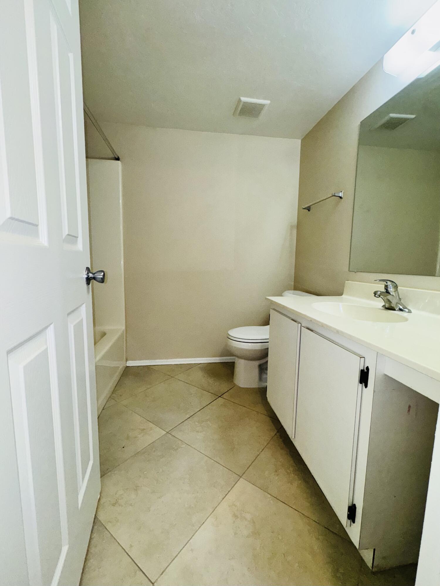 1708 Palm Beach Trace Drive Royal Palm Beach, FL 33411 - Photo 10 of 13 a bathroom with a sink a toilet and a mirror