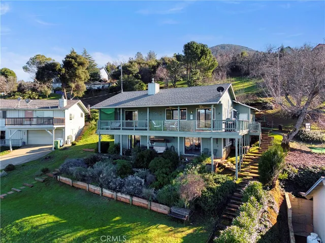 a front view of a house with a garden and swimming pool