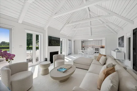 a living room with furniture a fireplace and a chandelier