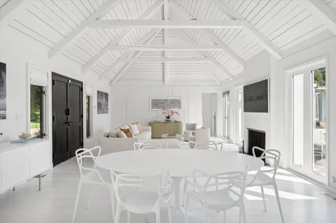 a living room with furniture floor to ceiling window and flat screen tv