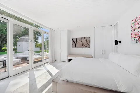 a bedroom with a white bed and a view of bathroom