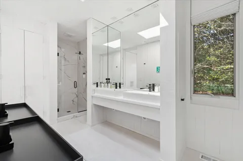 a spacious bedroom with a large bed and a flat tv screen on dresser