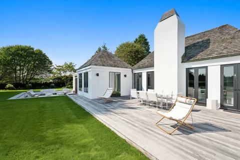 a view of house with backyard and outdoor seating