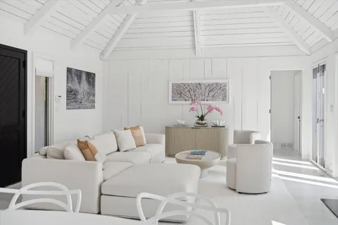 a living room with furniture and a painting on the wall