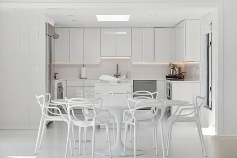 a kitchen with stainless steel appliances kitchen island granite countertop a table and chairs