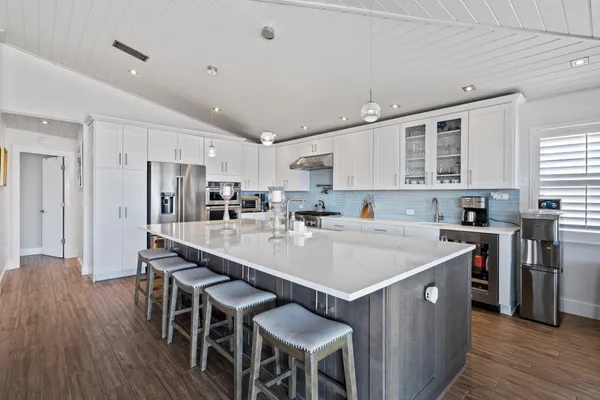 a large kitchen with stainless steel appliances lots of counter space and a sink