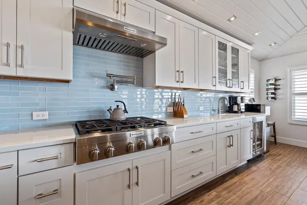 a kitchen with stainless steel appliances granite countertop a table chairs sink and cabinets