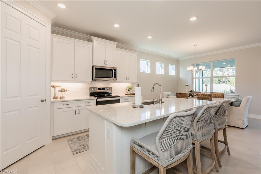 267 Tamarindo Lane Naples, FL 34114 - Photo 12 of 18 a kitchen with a dining table chairs and refrigerator