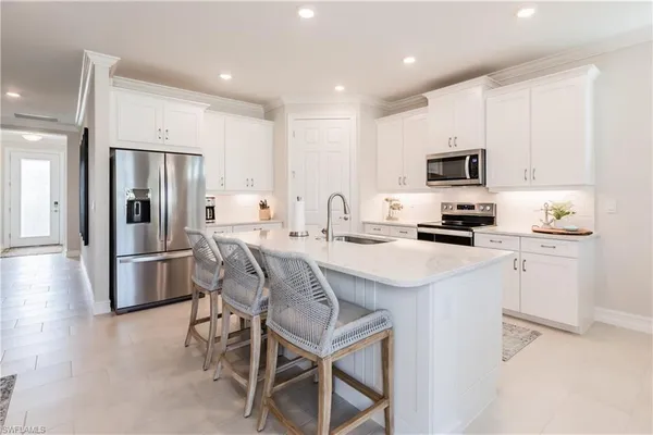 a kitchen with kitchen island a refrigerator stove and microwave
