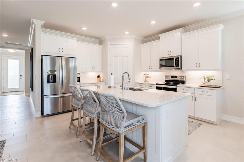 267 Tamarindo Lane Naples, FL 34114 - Photo 14 of 18 a kitchen with kitchen island a refrigerator stove and microwave