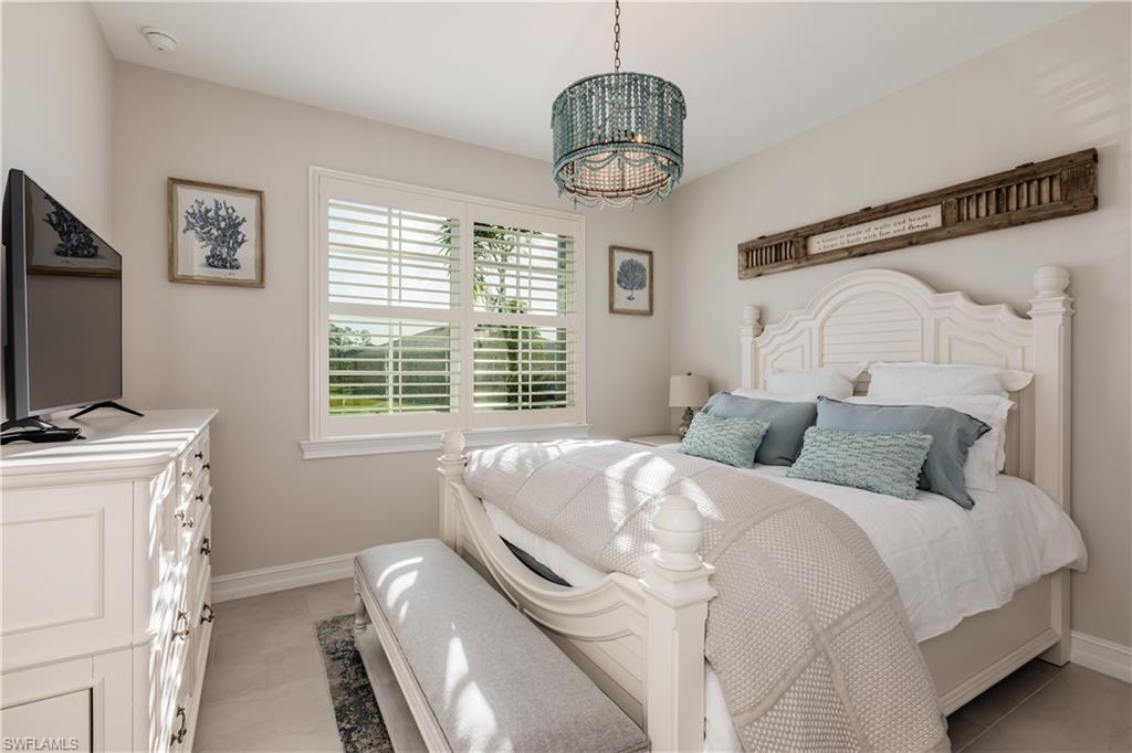 267 Tamarindo Lane Naples, FL 34114 - Photo 16 of 18 a bedroom with a bed and a chandelier