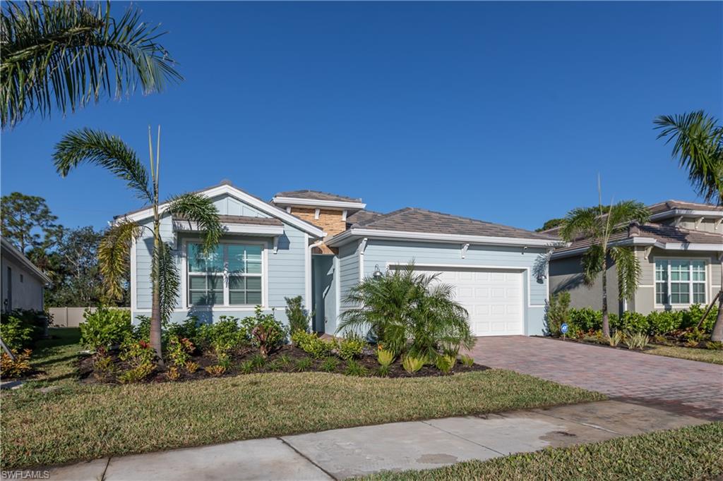 267 Tamarindo Lane Naples, FL 34114 - Photo 2 of 18 a front view of a house with a garden