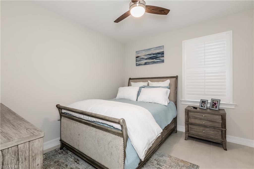267 Tamarindo Lane Naples, FL 34114 - Photo 9 of 18 a bedroom with a bed and a chandelier