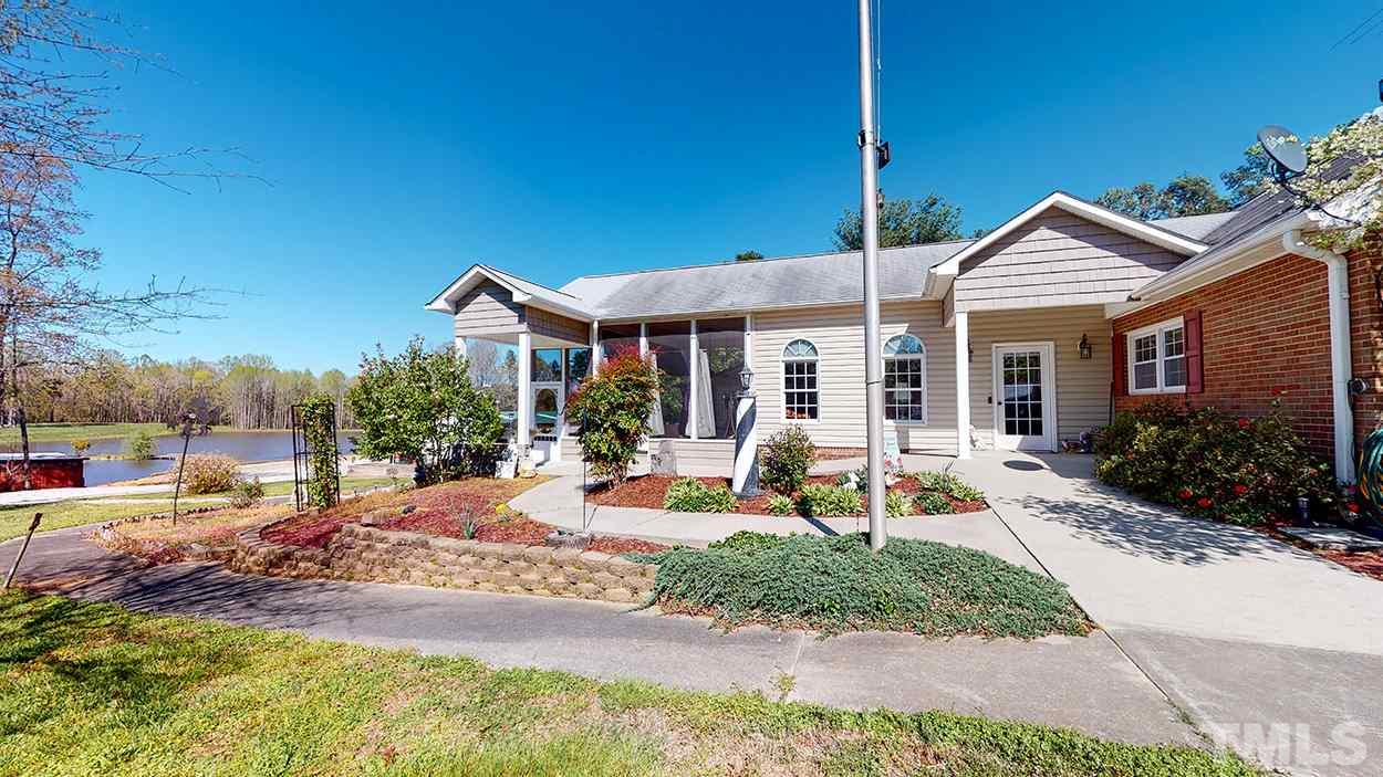 3111 Old Allensville Road Roxboro, NC 27574 - Photo 15 of 17 a view of a house with backyard sitting area and garden
