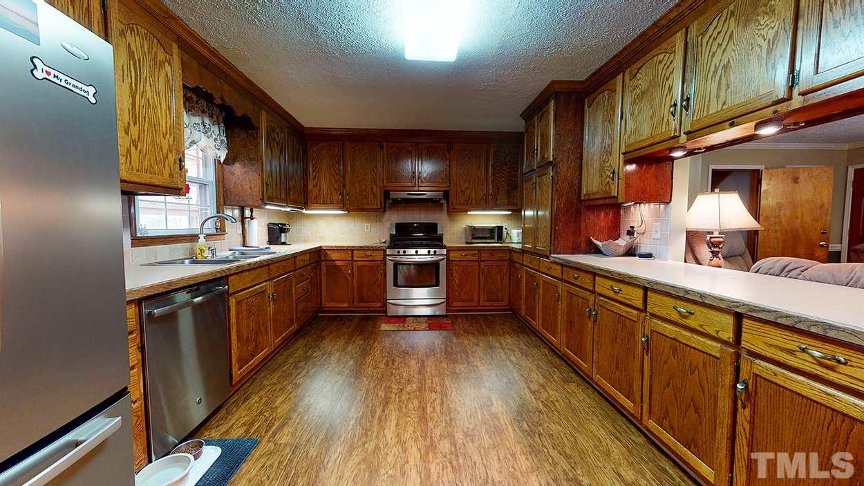 3111 Old Allensville Road Roxboro, NC 27574 - Photo 4 of 17 a kitchen with stainless steel appliances sink cabinets and wooden floor