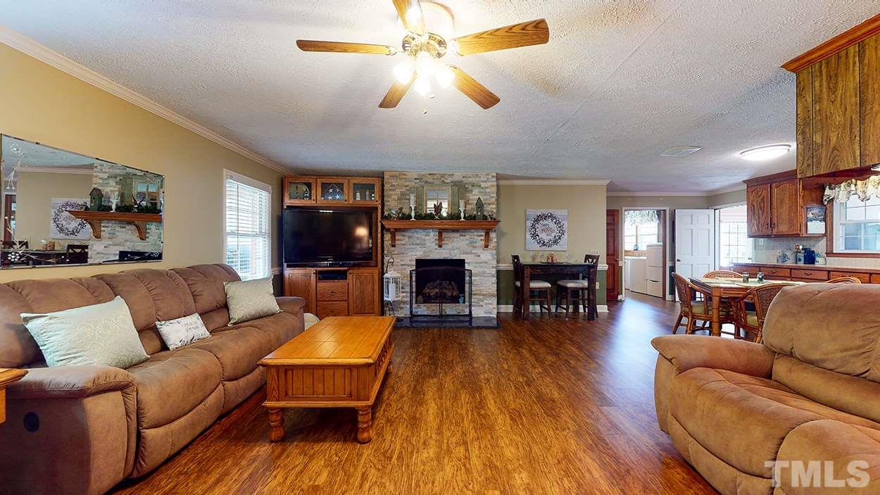 3111 Old Allensville Road Roxboro, NC 27574 - Photo 5 of 17 a living room with furniture a fireplace and a flat screen tv