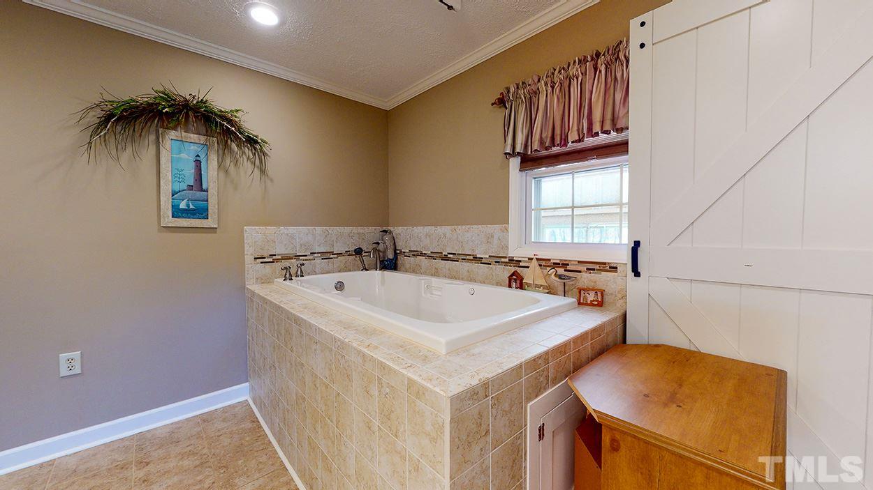 3111 Old Allensville Road Roxboro, NC 27574 - Photo 10 of 17 a bathroom with a sink a vanity and a bathtub