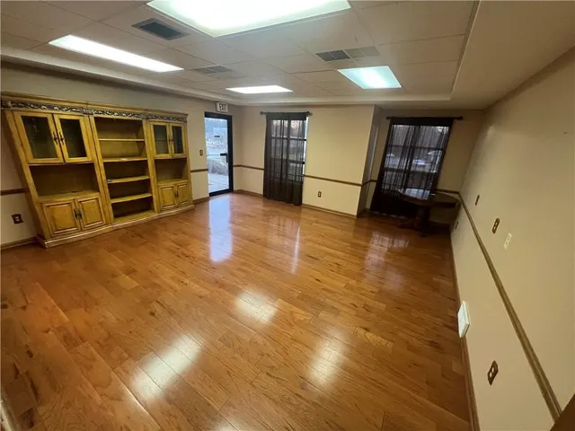 a view of an empty room with closet and windows
