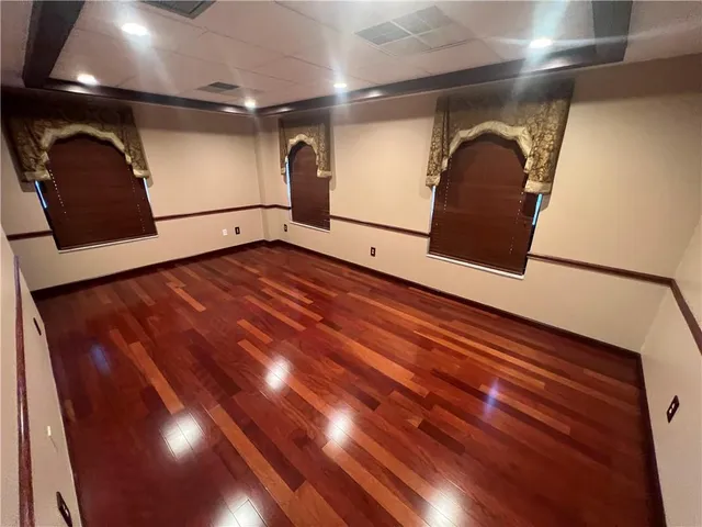 a view of an empty room with wooden floor