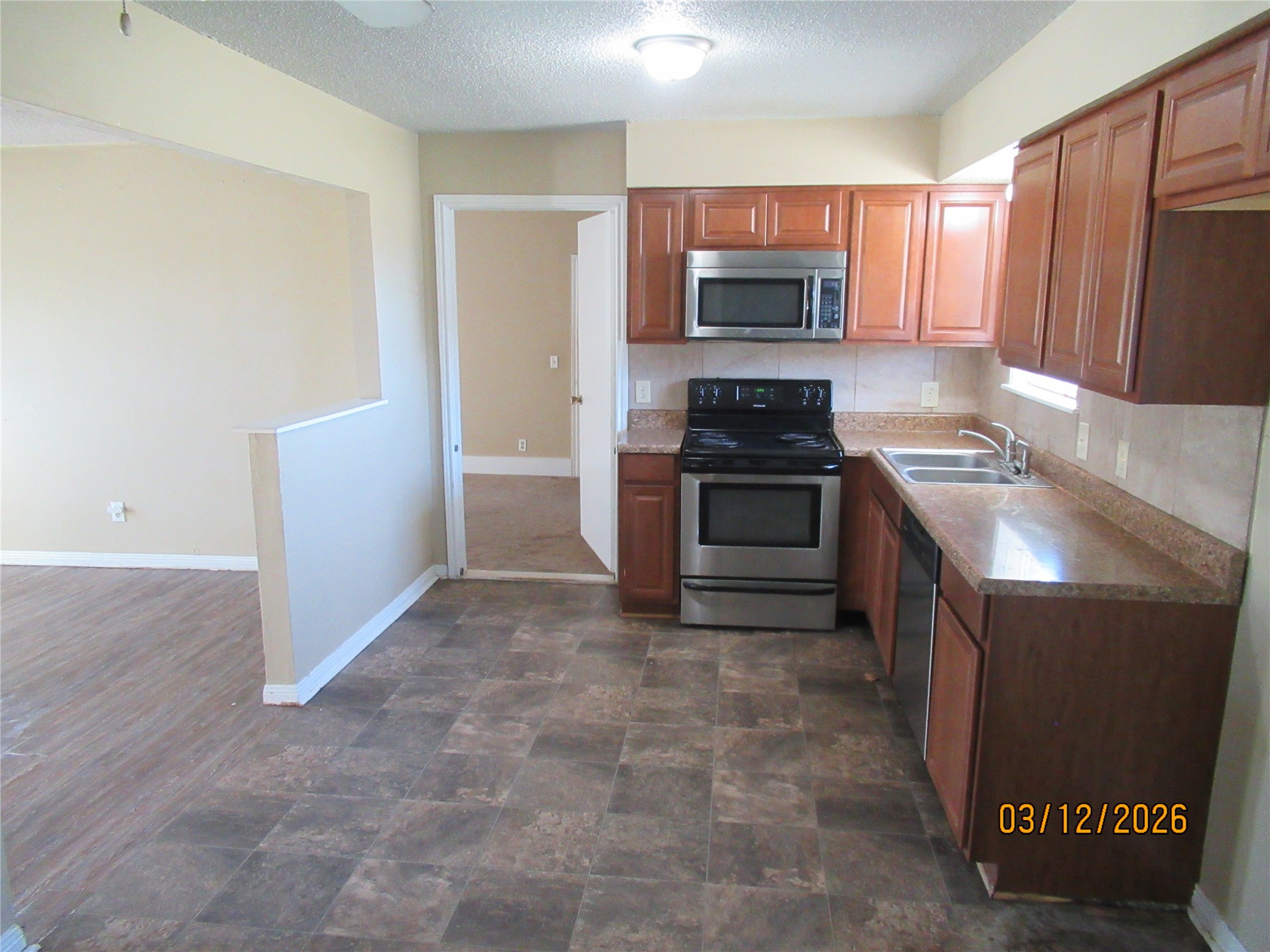 403 Lotus Street Lake Jackson, TX 77566 - Photo 14 of 29 a kitchen with granite countertop a refrigerator stove and microwave