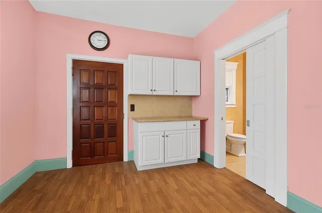 a view of a kitchen with wooden floor and a window