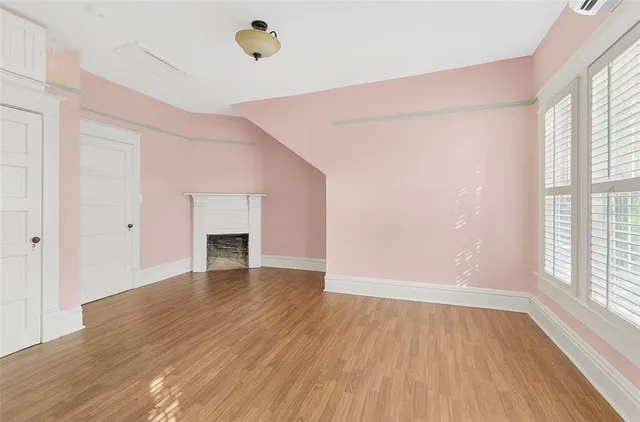 a view of empty room with wooden floor and fireplace