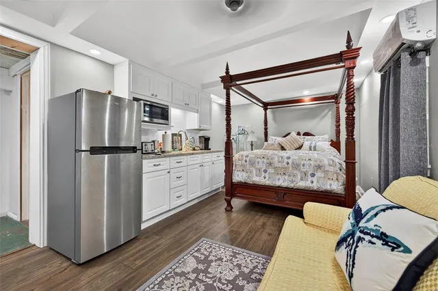 a bedroom with a bed and a refrigerator