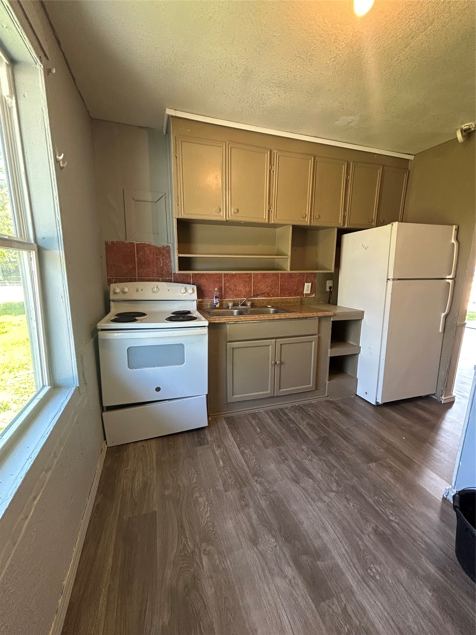 1102-11 West 10th Street Freeport, TX 77541 - Photo 6 of 10 a kitchen with a stove a sink and a refrigerator