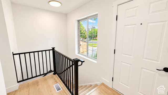 342 East 600 North Logan, UT 84321 - Photo 16 of 19 White paneled interior door with matte black hardware, wood-finish flooring, and a window with white trim
