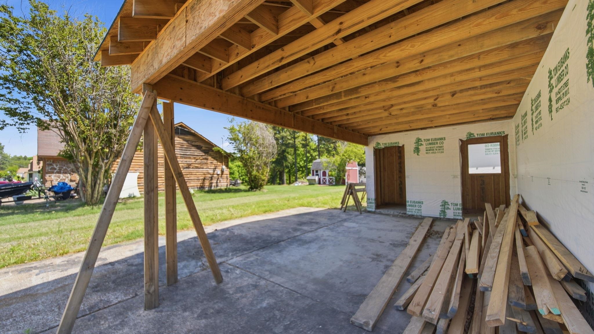 2278 Beaver Road Munford, TN 38058 - Photo 18 of 28 Open-air garage space with exposed wood joist ceiling, concrete flooring, and two framed entryways