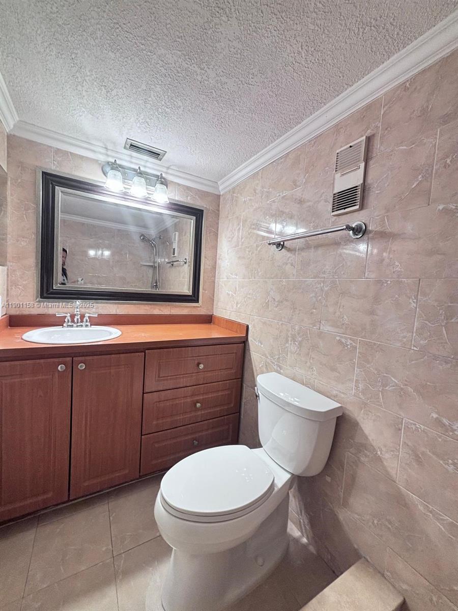 8740 Sherman Circle North, Unit 405 Miramar, FL 33025 - Photo 12 of 20 a bathroom with a toilet sink and mirror