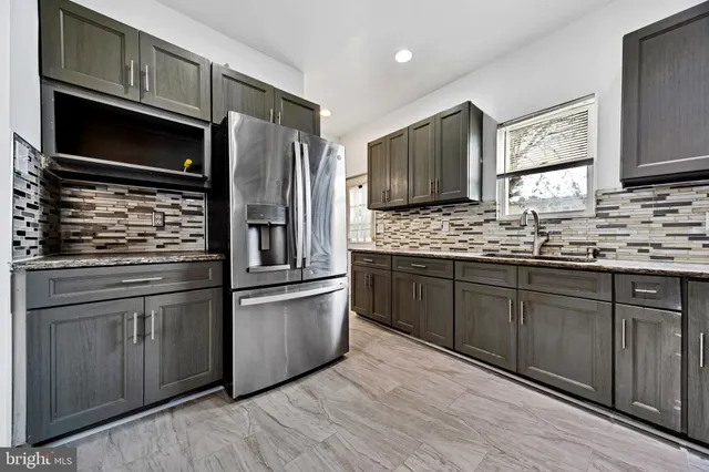 a kitchen with stainless steel appliances granite countertop a refrigerator stove and sink