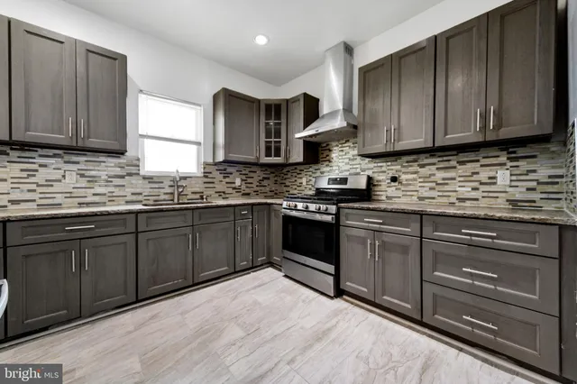 a kitchen with stainless steel appliances granite countertop wooden cabinets a stove top oven a sink and dishwasher