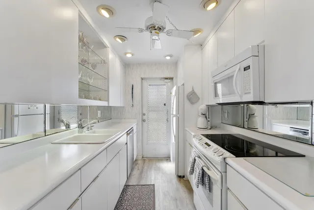 a kitchen with white cabinets and appliances