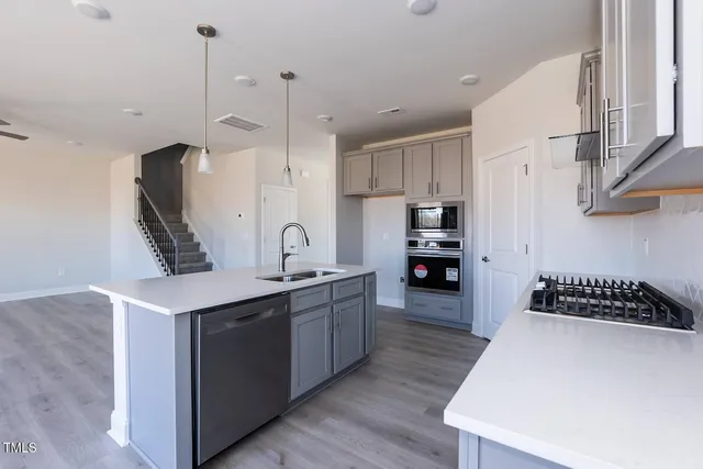 a kitchen with stainless steel appliances granite countertop a sink stove and refrigerator