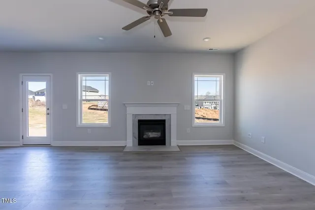 a view of an empty room with a window and fireplace