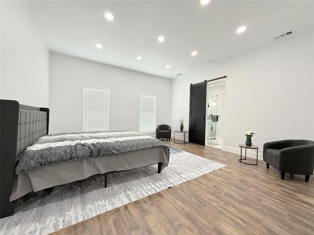 4602 Sycamore Street Dallas, TX 75204 - Photo 15 of 24 a spacious bedroom with a bed and wooden floor