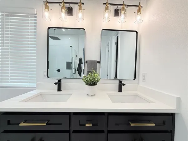 a bathroom with double vanity sinks and a mirror