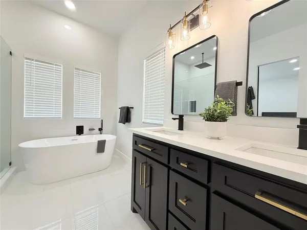 a spacious bathroom with a bathtub sink and mirror