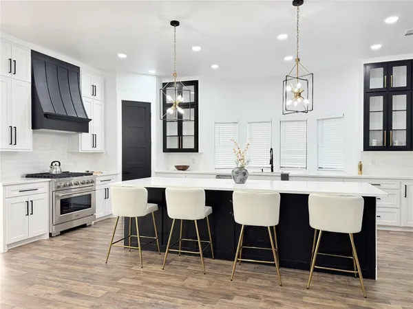 a kitchen with stainless steel appliances kitchen island granite countertop a dining table chairs and sink