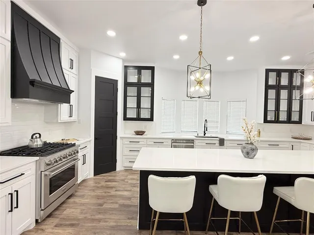 a kitchen with stainless steel appliances a sink stove and refrigerator