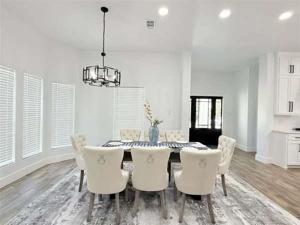 a view of a dining room with furniture wooden floor and chandelier