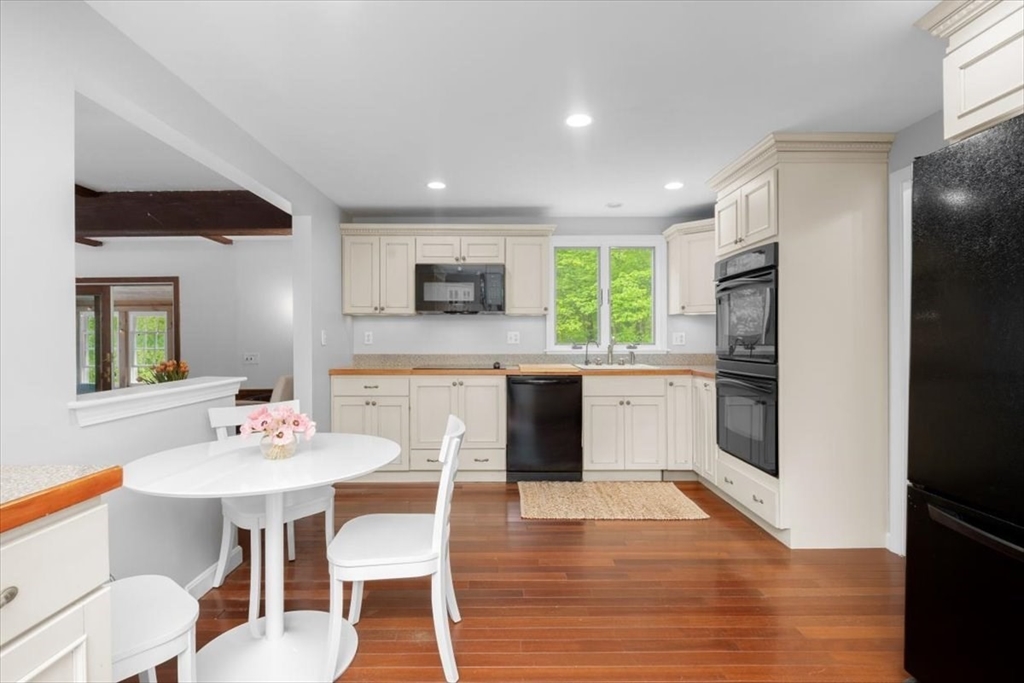 48 Knollwood Road Norwell, MA 02061 - Photo 12 of 41 a kitchen with stainless steel appliances kitchen island granite countertop a refrigerator a stove a sink dishwasher and white cabinets with wooden floor