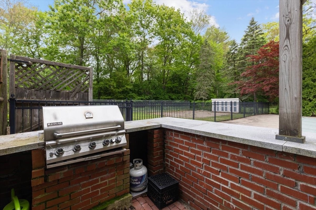 48 Knollwood Road Norwell, MA 02061 - Photo 30 of 41 a view of a patio with a table and chairs with barbeque grill and wooden fence