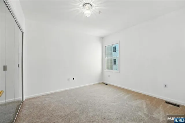 an empty room with a ceiling fan and a window