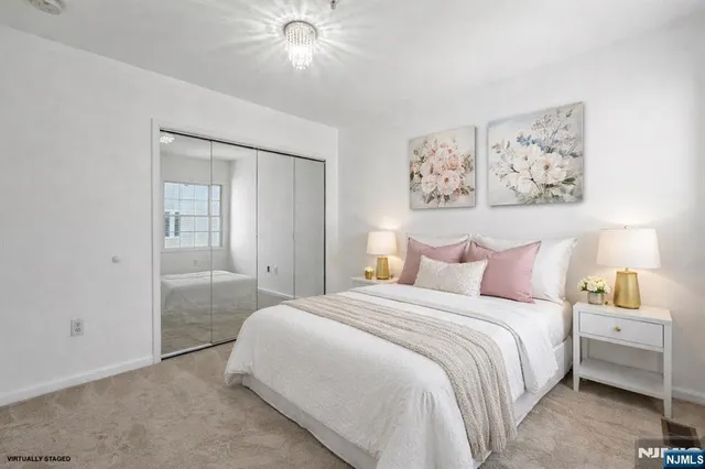 a bedroom with a large bed and a chandelier