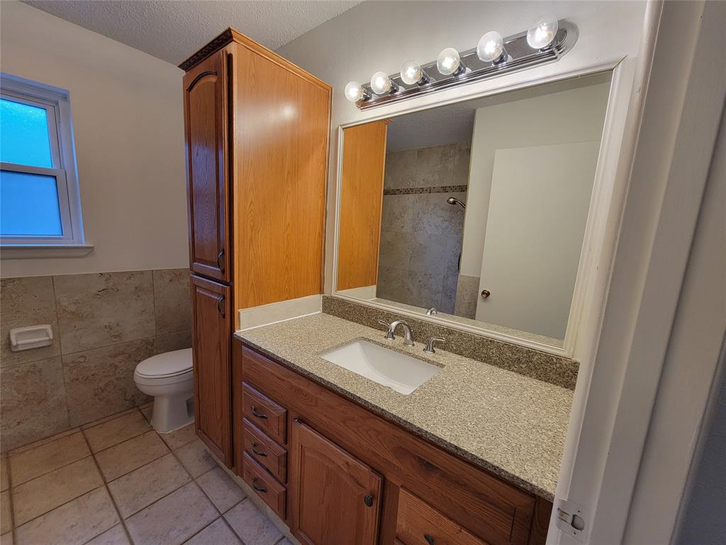 1000 Springdale Road Bedford, TX 76021 - Photo 22 of 36 Hall bathroom has ample storage space in these built-in cabinets.